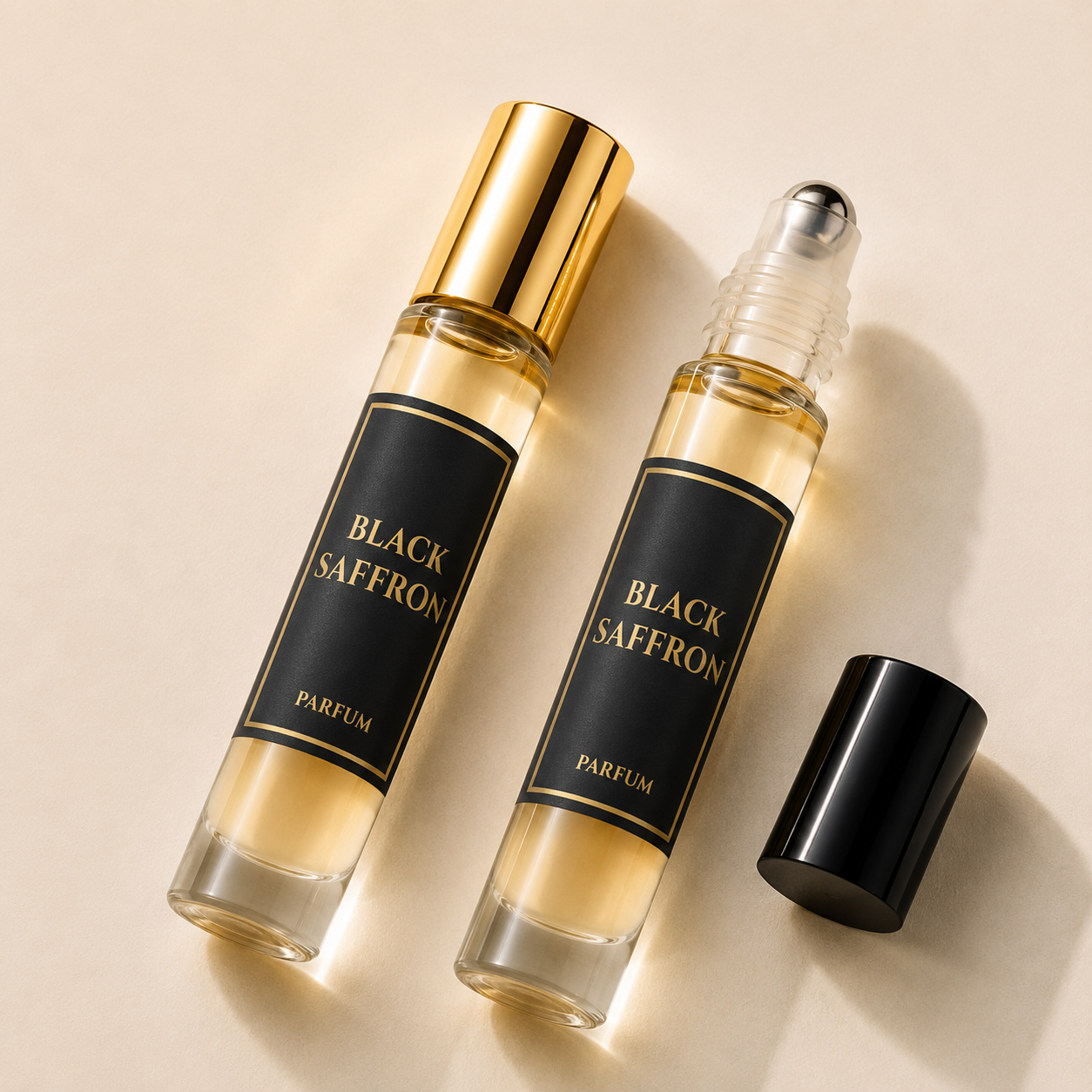 Two perfume rollerball bottles labeled BLACK SAFFRON PARFUM, one with a shiny gold cap and one with a clear cap and silver roller ball, shown on a warm beige background with the black cap placed beside them.