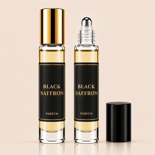 Two clear glass perfume roller bottles labeled BLACK SAFFRON PARFUM with black labels and gold lettering, one bottle with a gold cap and one with a silver roller top, shown on a light beige background with a black cap placed beside them.
