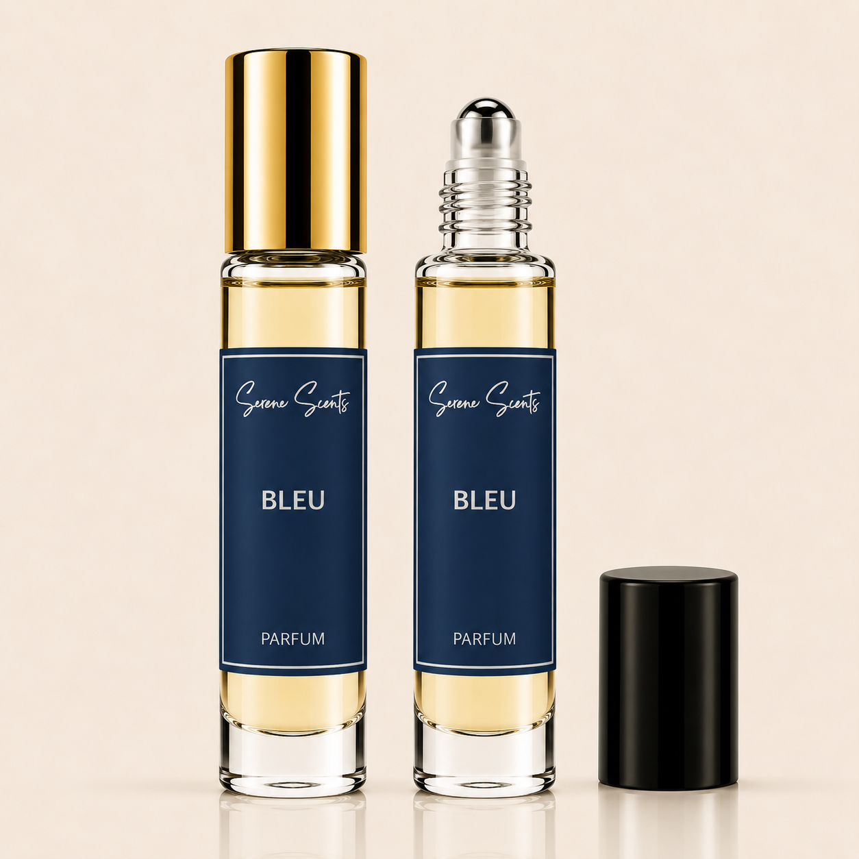 Two clear glass perfume roller bottles labeled 'Scenic Scents BLEU PARFUM' with pale yellow liquid inside, one capped with a shiny gold roller top and the other with a silver roller ball, shown beside a detached black cap on a warm beige background.