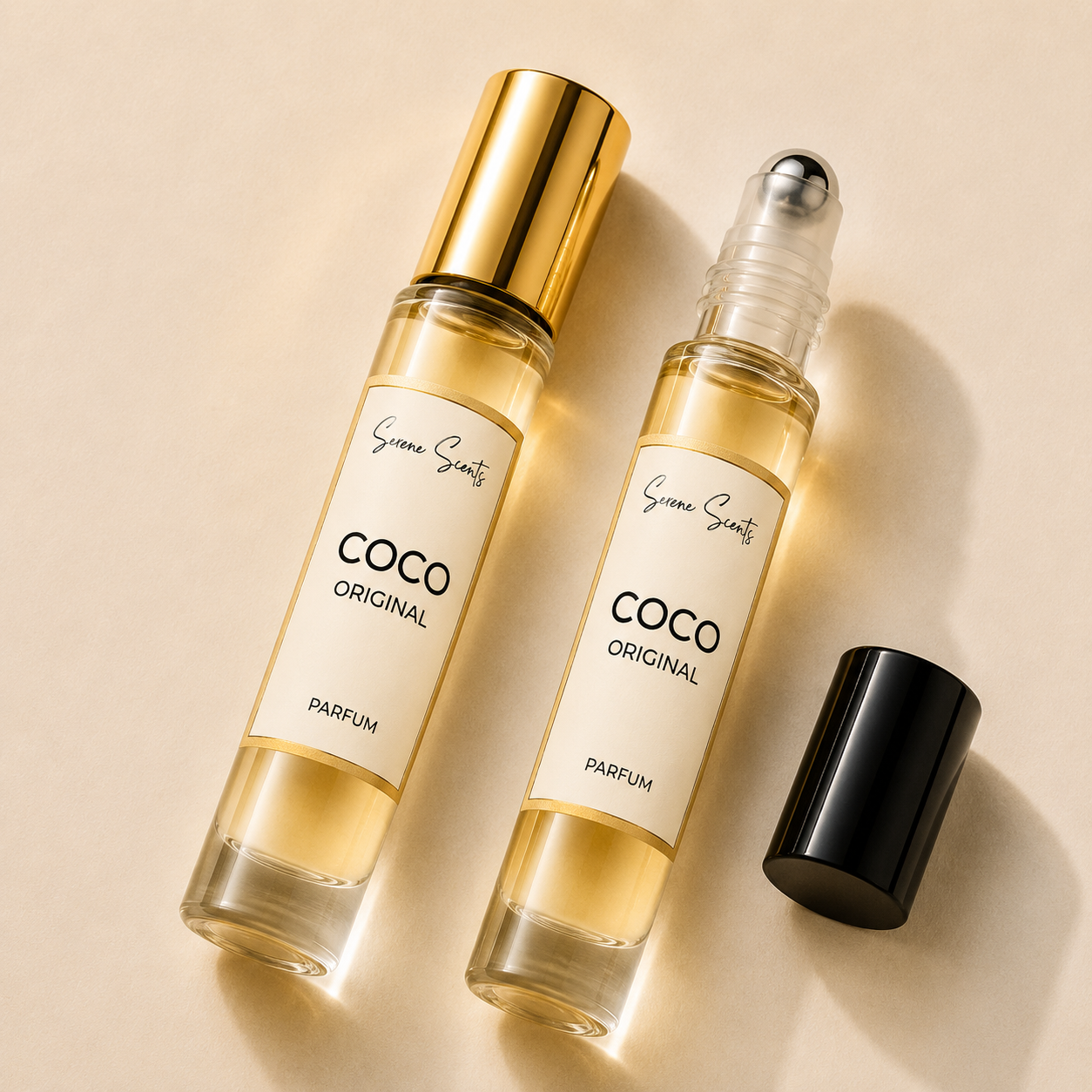 Two clear perfume rollerball bottles with cream labels reading 'COCO ORIGINAL PARFUM' and 'Synergy Scents' are arranged on a warm beige background, one bottle capped in gold and the other uncapped with its black cap placed beside it.