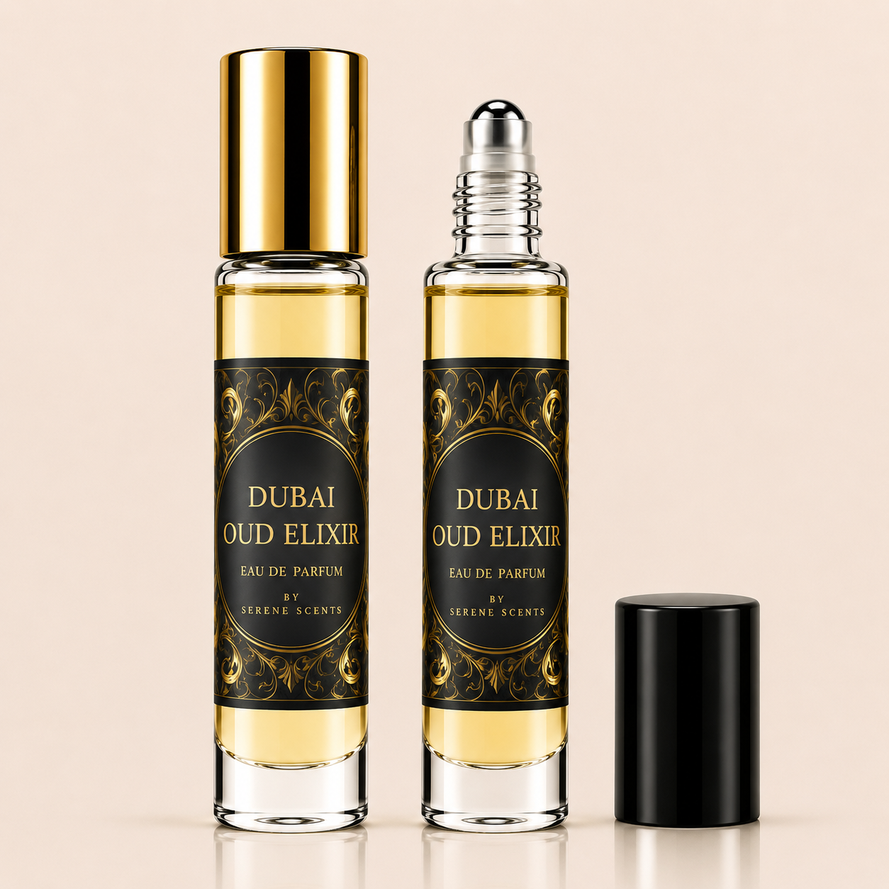 Two glass rollerball perfume bottles labeled 'DUBAI OUD ELIXIR' with ornate black and gold labels, one bottle with a shiny gold cap and one with a silver rollerball top, plus a separate black cap on a light beige background.