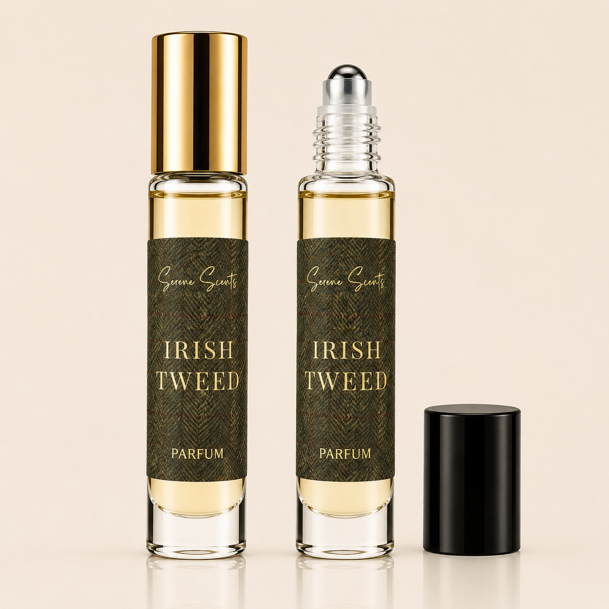 Two glass perfume roller bottles labeled 'Irish Tweed Parfum' with dark olive-green labels and gold lettering, one with a gold cap and one with a clear cap showing the roller ball, plus a separate black cap on a light beige background.