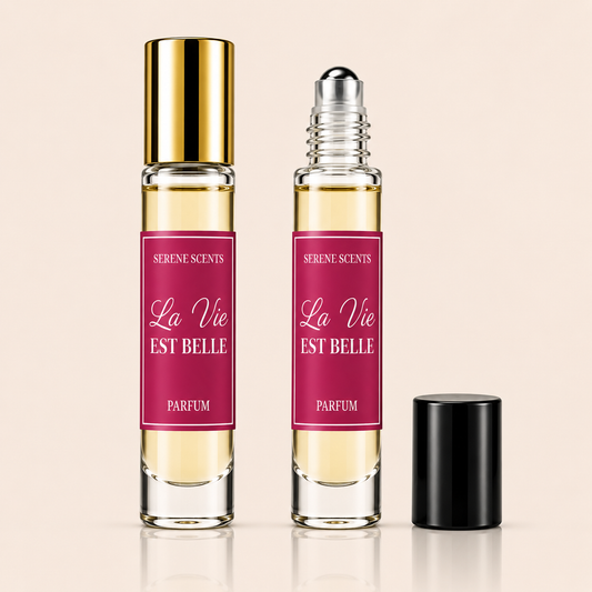 Two perfume roll-on bottles labeled 'La Vie EST BELLE' by Serene Scents, one with a gold cap and one with a black cap, shown on a light beige background.