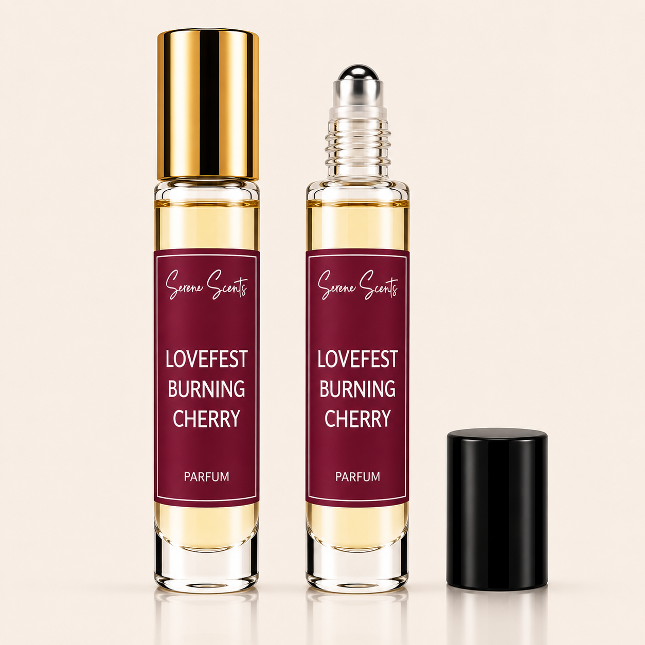 Two clear glass rollerball perfume bottles with deep burgundy labels reading 'Lovefest Burning Cherry' and 'Scenic Scents' at the top, shown on a light beige background. One bottle has a shiny gold cap, the other has a clear cap with a silver rollerball, and a separate black cap sits to the right.