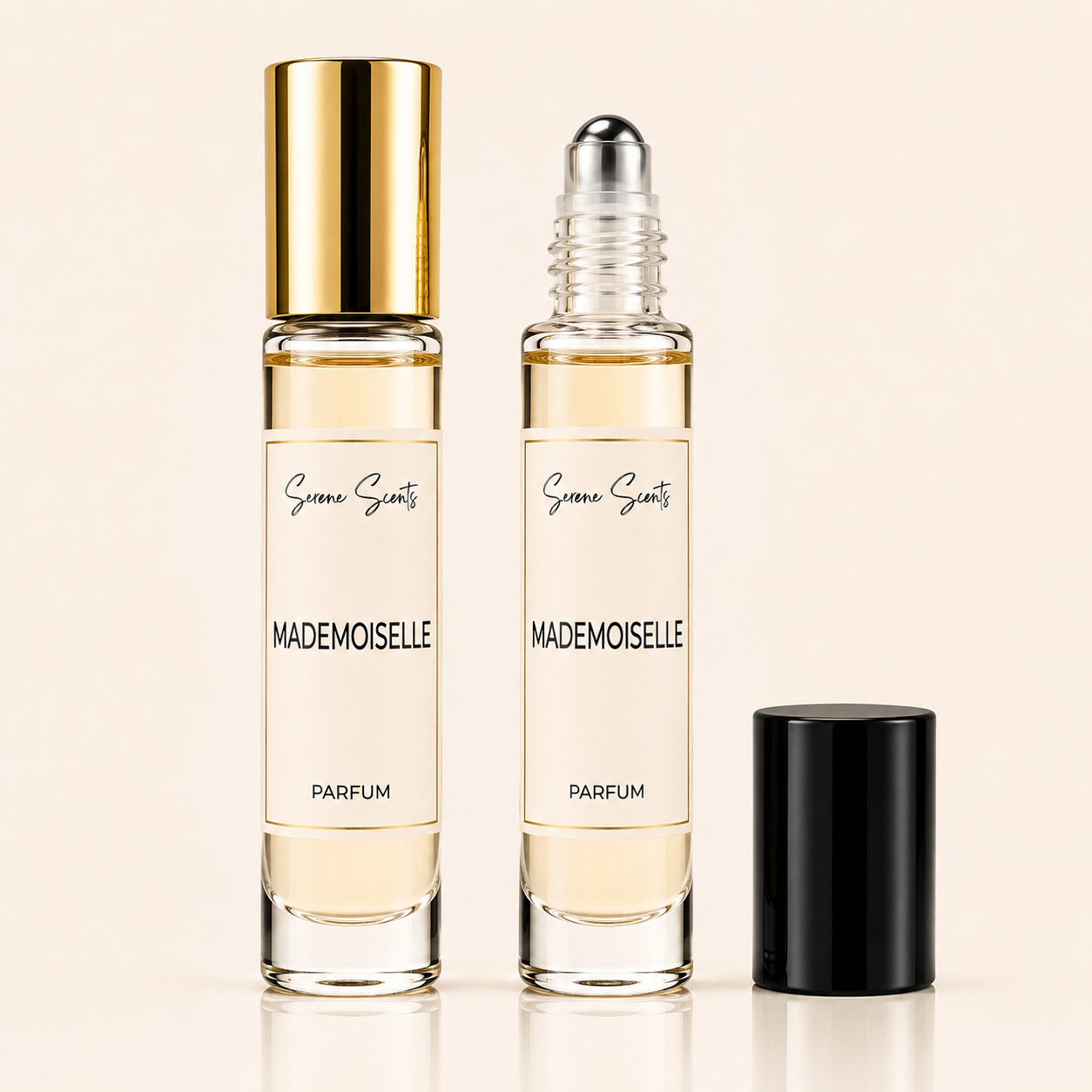 Two clear glass perfume roller bottles with pale yellow liquid and cream labels, one with a gold cap and one with a silver roller top, alongside a black cap on a light beige background. The label reads 'Scent of Scenery' and 'MADEMOISELLE PARFUM'.