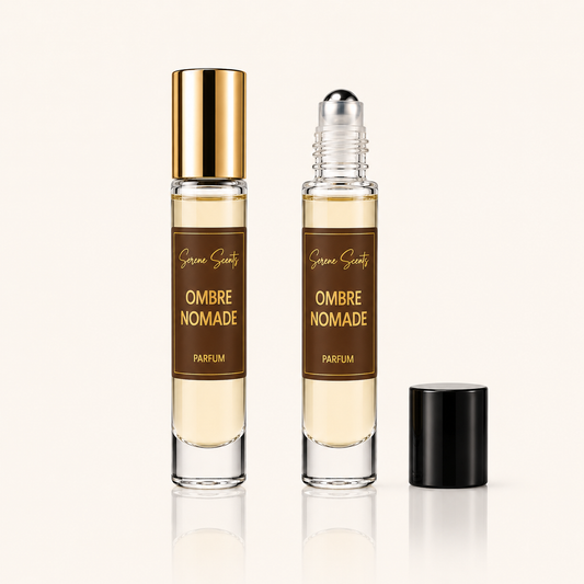 Two clear cylindrical perfume roller bottles with brown labels reading 'Sarah Sweets Ombre Nomade Parfum' are shown on a light beige background, one with a gold cap and one with a black cap removed and placed beside it.