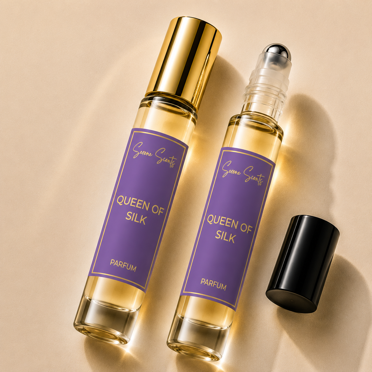 Two perfume rollerball bottles labeled 'Queen of Silk' by Scenic Scents, with one bottle open and its black cap placed beside it, on a warm beige background.