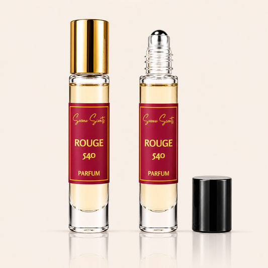 Two clear glass perfume roller bottles with pale yellow liquid, red labels reading 'Succé Scents ROUGE 540 PARFUM', and gold-toned caps, shown on a light beige background with one bottle cap placed beside it.