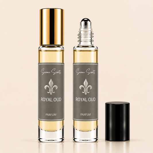 Two clear glass perfume roller bottles with pale golden liquid, gray labels reading 'Green Scents ROYAL OUD PARFUM,' one bottle topped with a shiny gold cap, the other with a clear roller top, and a separate black cap standing beside them on a warm beige background.