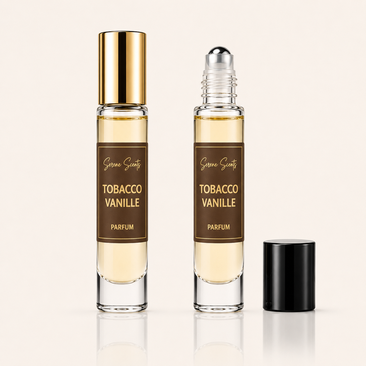Two clear glass perfume rollerball bottles labeled 'Scenes Scenery Tobacco Vanille Parfum' on a light beige background, with one bottle showing a gold cap and the other showing a silver rollerball, plus a separate black cap standing beside them.